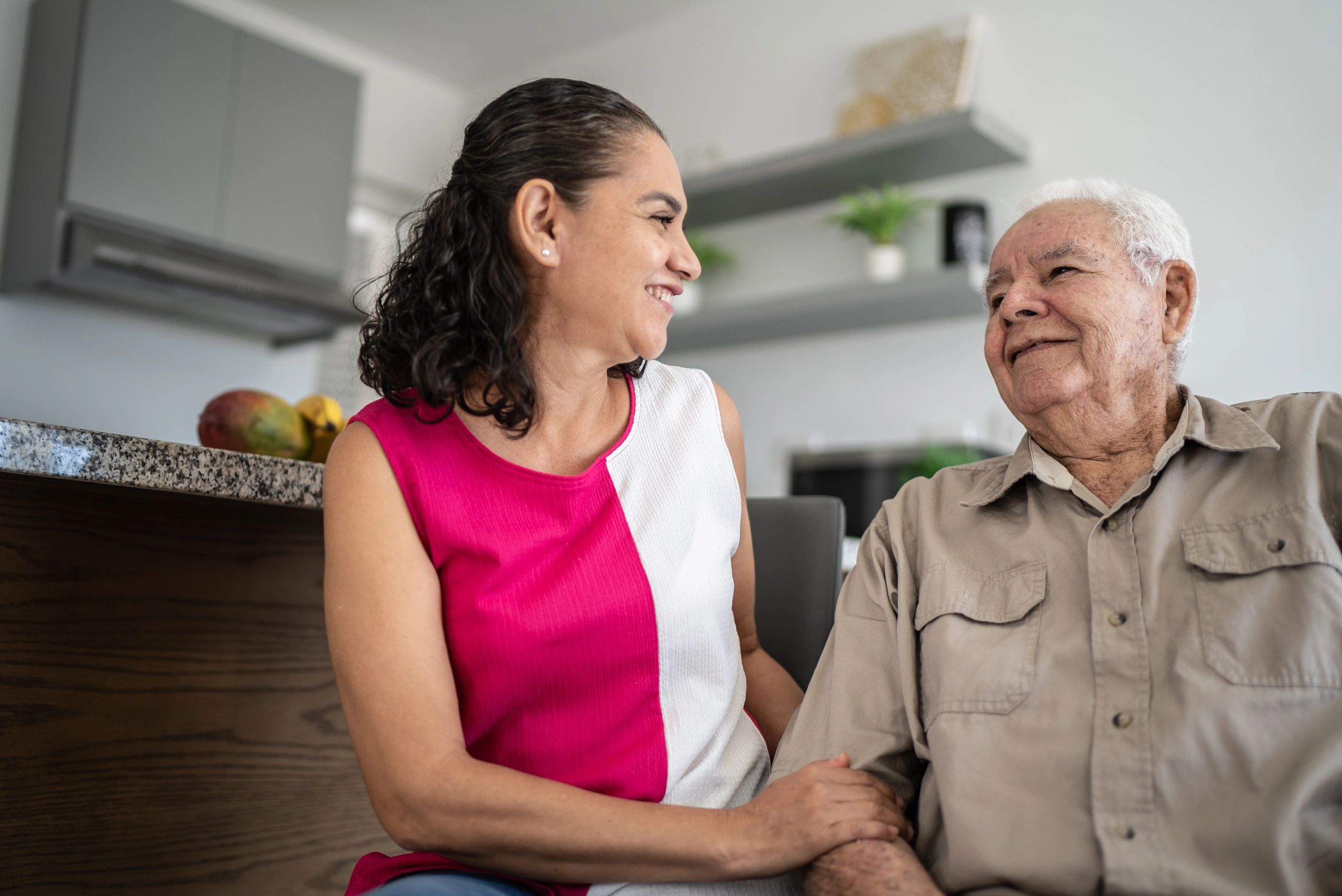 Senior client and caregiver talking at home